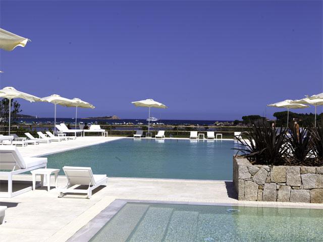 Ligbedden en parasols rondom het zwembad - Vakantie resort Paradise in Sardinie